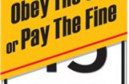 "Obey the sign or pay the fine" banner over a speed limit sign