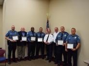 Officers standing together holding certificates
