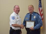 Older officer holding certificate and shaking another officers hand